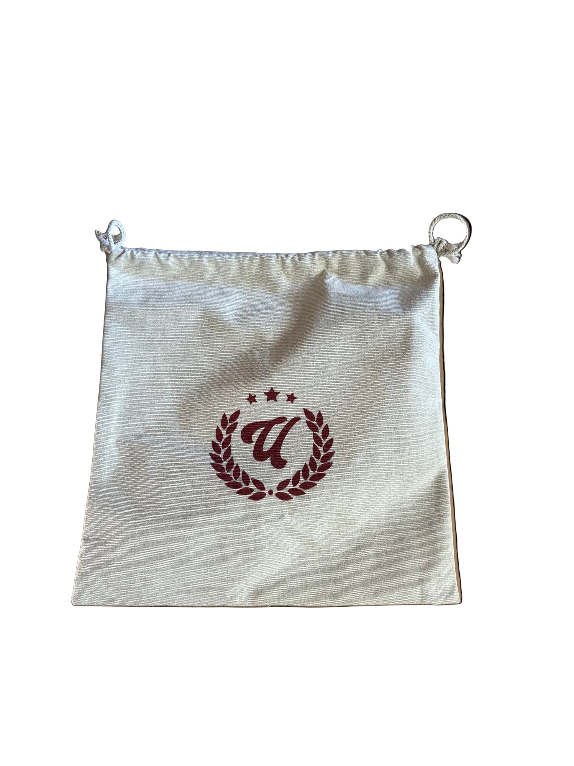 White drawstring bag with a red logo on a wooden surface